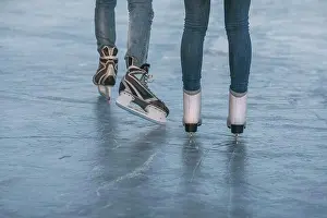Midadult Men Prints: Low section of couple ice-skating on rink