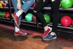 Jean Prints: Low section of female friends wearing shoes standing by bowling rack