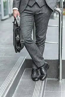 Symbolic Pictures Prints: Low section view businessman holding shoulder bag