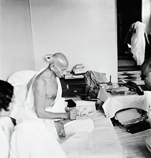 Redaktionelle Prints: Mahatma Gandhi signing his photograph at Birla House