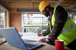 50 54 Years Prints: Male architect reviewing blueprints at construction site