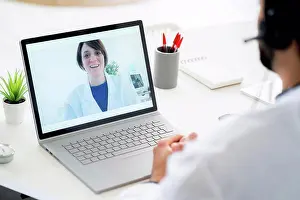 Competence Prints: Male doctor discussing with female colleague on video conference through laptop