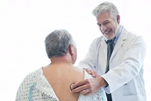 Examining Prints: Male doctor examining patient in hospital gown