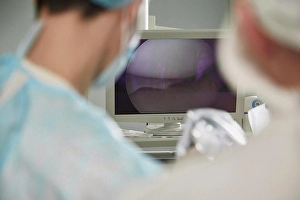 Device Screen Prints: Male doctor looking at monitoring equipment in operating room