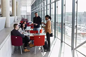 Cafeteria Prints: Male and female friends discussing while studying in university cafeteria