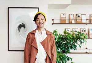 Balance Prints: Male Japanese professional standing in a co-working space, smiling at camera