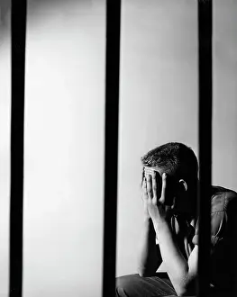 Suffer Prints: Male prisoner sitting in prison cell