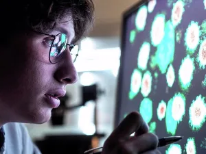 Analytics Prints: Male scientist researching on biological cell on computer screen in laboratory