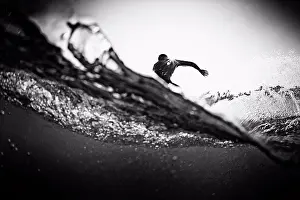 Agility Prints: Male surfer making cutback from behind ocean wave