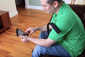 Electronic Prints: Man after anterior cruciate ligament (ACL) surgery with cane and using an digital tablet at home