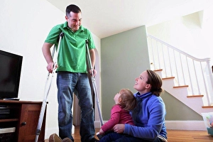 Crutch Prints: Man after anterior cruciate ligament (ACL) surgery with wife and daughter at home