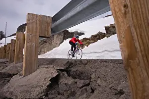 Biking Prints: A man climbing uphill on a bicyle in winter on Donner Summit in California