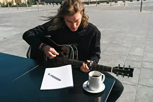 Tablet Prints: man composing music playing the guitar and reading