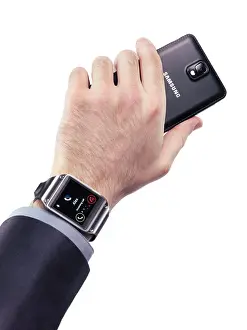 Electronics Prints: Man hand with Samsung Galaxy Gear smartwatch and a smartphone isolated on white background