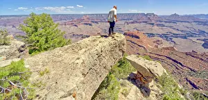 Arid Prints: A man looking over the edge of a cliff overhang west of Shoshone Point at Grand Canyon Arizona