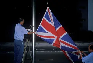 Man lowering British Union Jack flag in Hong Kong