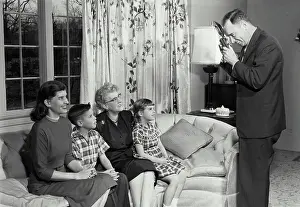 Senior Women Prints: Man photographing family on sofa