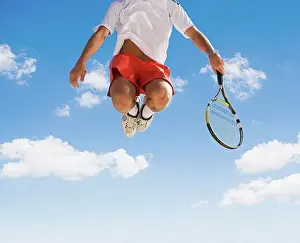 Playful Prints: Man playing tennis against blue sky
