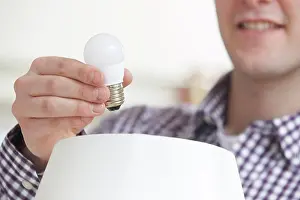 Bill Prints: Man Putting Low Energy LED Lightbulb Into Lamp At Home