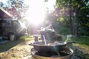Lens Flare Prints: man setting up dinner at campground food on stove