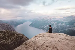 Hike Prints: Man sitting in rock at edge of cliff at Preikestolen, Norway