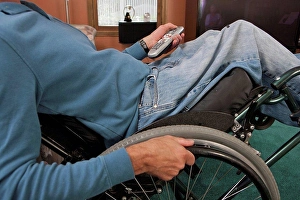 Adaptive Prints: Man with spinal cord injury in a wheelchair using a remote control