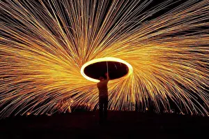 Turning Prints: Man Spinning Ball Of Burning Steel Wool At Night, Petersfield, Hampshire, Uk
