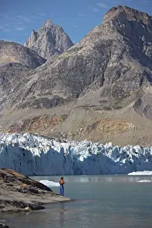 Glacier Prints: man standing at the water's edge of a fjord in Greenland