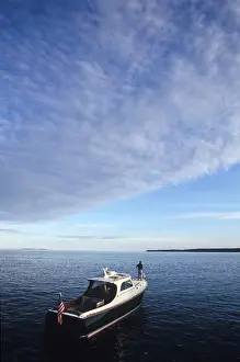 Nautical Prints: A man stands on the bow of a motor boat near Southwest Harbor, Maine