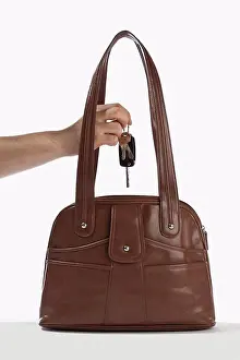 Leather Prints: Detail of a man taking keys out of a handbag