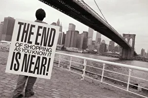 Activist Prints: Man wearing placard saying THE END OF SHOPPING AS YOU KNOW IT IS NEAR! and looking out at Manhattan