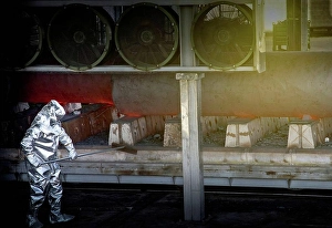Manual Worker Prints: Man wearing silver heat-protective suit working in a steel factory