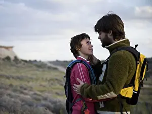 Hugging Prints: Man and woman with backpacks embracing outdoors
