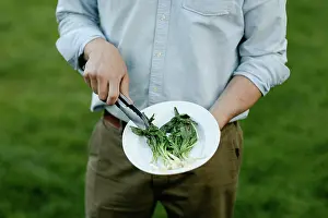 Tableware Prints: Man's hands holding a platter of grilled and wilted ramps