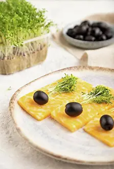 Cheese Prints: Marble cheese with olives and watercress microgreen on gray concrete background and linen textile