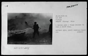 March Prints: A Marine utilizes a flamethrower to incinerate a trash dump during the Vietnam War