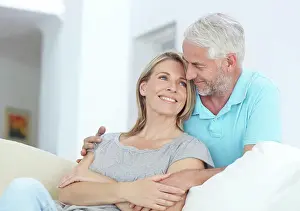 Sofa Prints: Mature couple, relax and hug on sofa with love