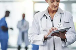 Mature female doctor on a digital tablet at the hospital
