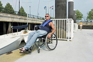 Handicapped Prints: Mature man sitting in a wheelchair at a harbor for adaptive sailing