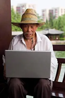 Computers Prints: Mature man with straw hat and laptop outdoors