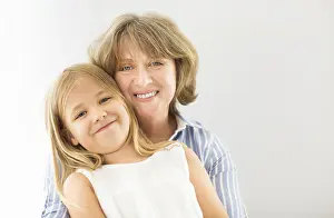 Grandma Prints: Mature woman embrace with young girl. Grandmother and girl