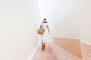 45 To 50 Years Prints: Mature woman wearing hat walking on footpath amidst walls