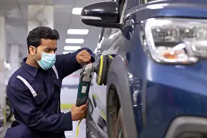 India Prints: mechanic polishing a car with an electric orbital polisher in auto repair Shop