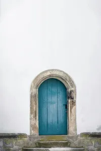 Minimal Prints: Medieval arched door. Aged wooden door in blue color with stone stairs and white wall