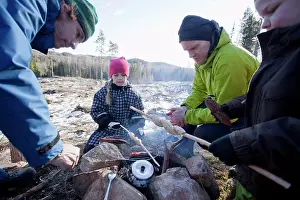 Mid Adultman Prints: Men cooking while children looking at camping site