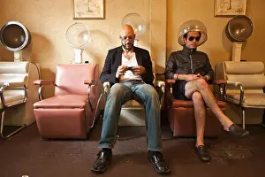 30 34 Years Prints: Two men sitting in old salon hair drying chairs