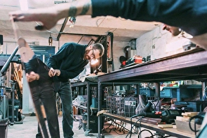 Business And Occupation Prints: Metalworkers inspecting sheet copper in forge workshop
