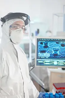 Analysis Prints: Microbiologist in ppe suit standing in laboratory looking at camera