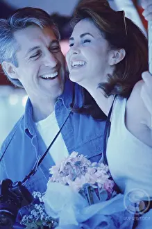 Medium Length Hair Prints: Mid adult man giving a bouquet of flowers to a mid adult woman