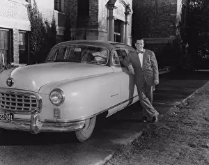 Personal Prints: Mid adult man standing with a car, 1950 Nash Ambassador Super Sedan